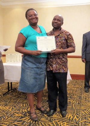 Mentor Dailes Nsofwa from CDC Zambia presents a certificate of completion to Kenneth Ngoma from Kasama General Hospital Laboratory.